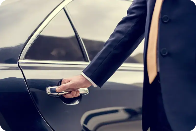 Chauffeur opening the car door for sedan rental